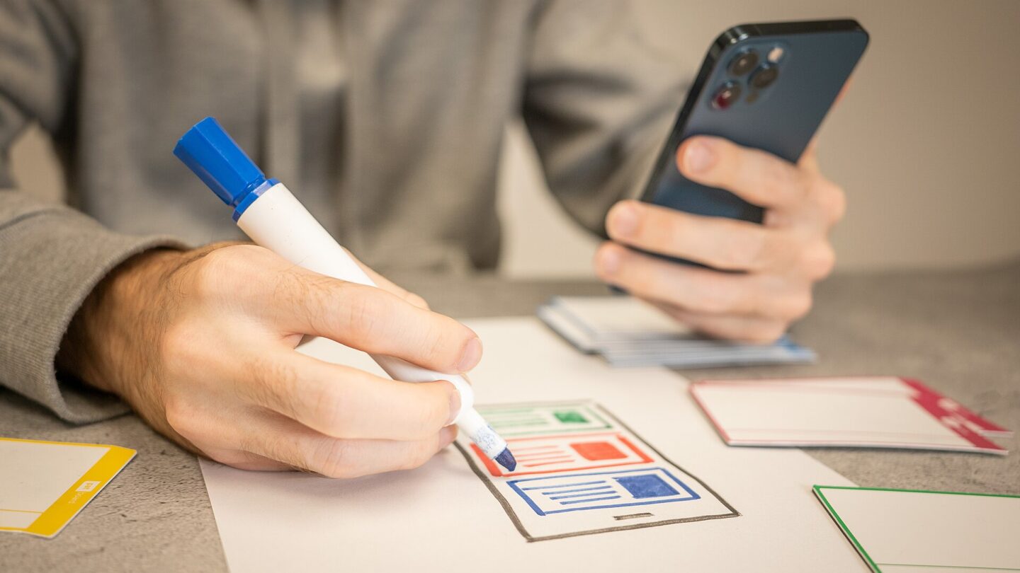 UX designer sketching mobile website wireframes during a website redesign