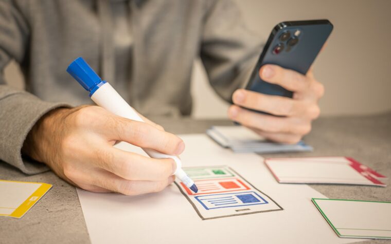 UX designer sketching mobile website wireframes during a website redesign